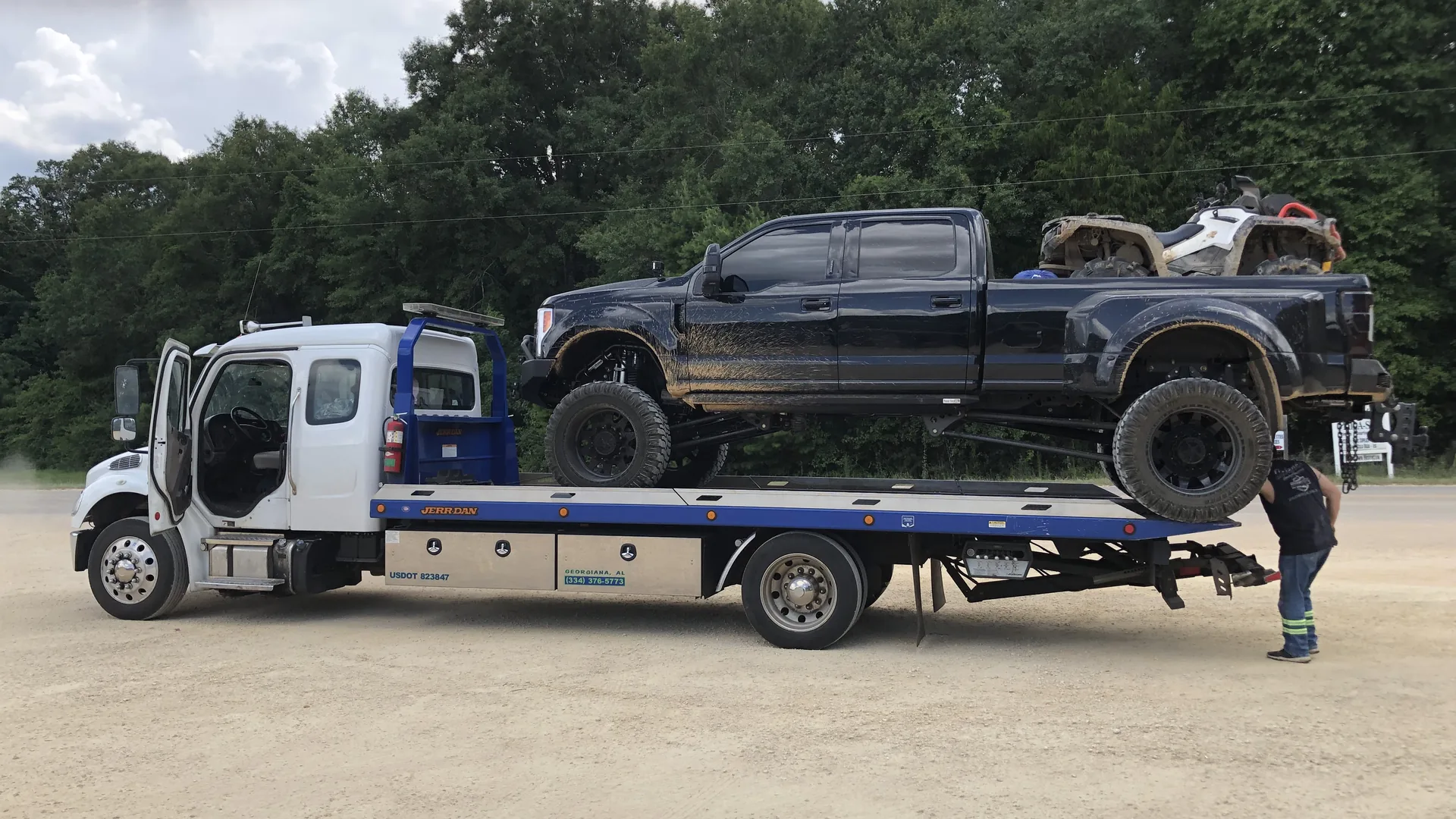 Lifted off-road truck being transported on a flatbed